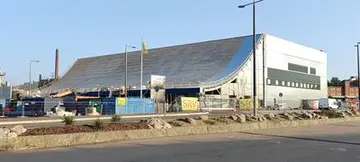 Pohjoismaiden suurin roikkuva puukatto harjakorkeudessaan – Kotkan Satama Areena avautuu elokuussa 2023